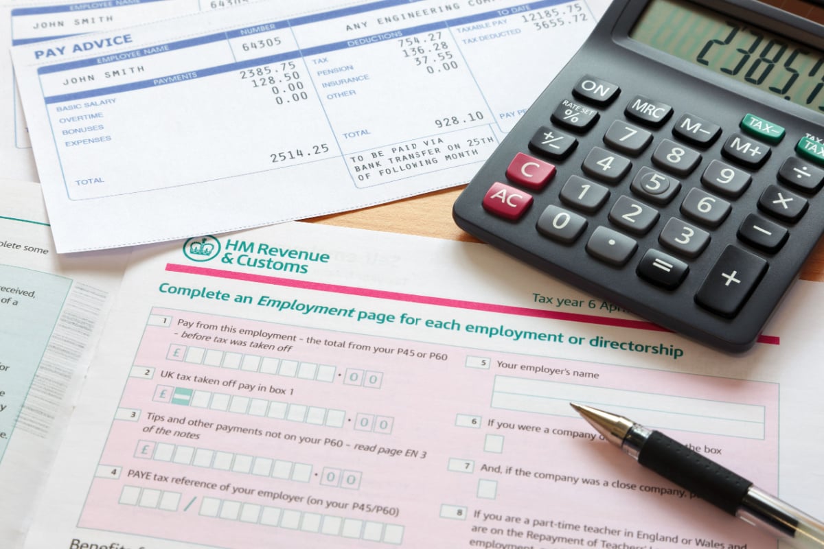UK tax return sheet, calculator and pen