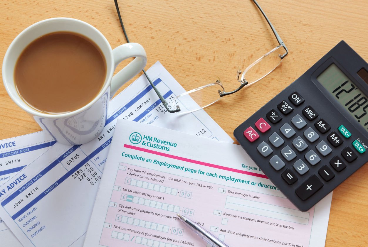 EIS income tax form being filled out alongside cup of tea, calculator and pair of glasses