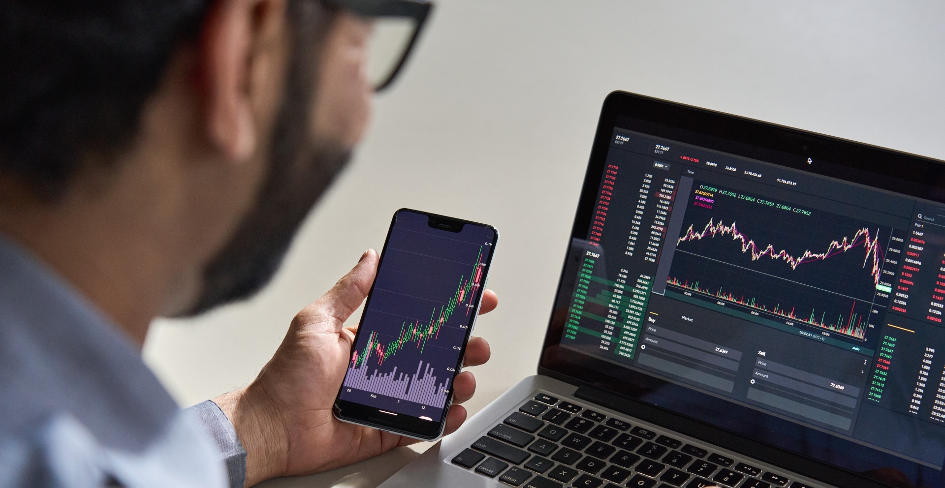 investor looking at investment performance on laptop and phone